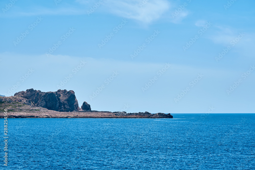 Rocky sea coast of Crete, Greece under a clear blue sky. Copy space.