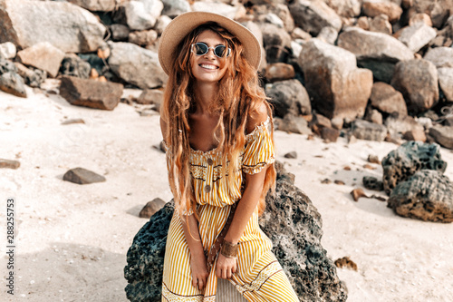 beautiful young stylish boho woman in elegant dress outdoors wearing hat and ...