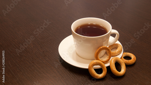 cup of black tea on a saucer with bagels