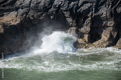 Fototapeta Naklejka Na Ścianę i Meble -  Large waves blowing through a hole in rocks in Boscastle