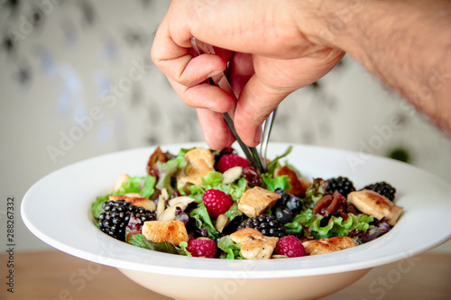 Food stylist hands working in a salad bowl