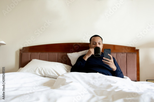 asian man wake up in the morning and enjoying cup of coffee