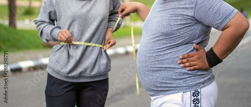 Obraz na plátně Two people, muslim woman and fat man, proportional and over weight, overweight a