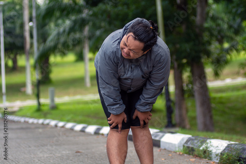 a man who is overweight is exhausted when he is trying to lose weight by running
