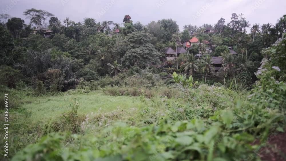 Rising shot of a village in the middle of an indonesian jungle, on a cloudy day Rising shot of a village in the middle of an indonesian jungle, on a cloudy day