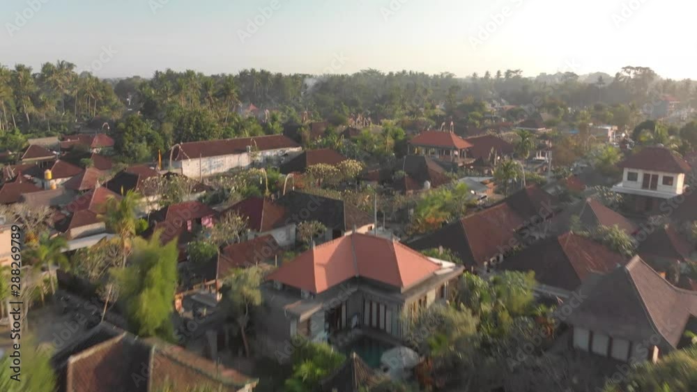 Forward drone shot of a small Bali village, with many plants and fields, on a sunny evening Forward drone shot of a small Bali village, with many plants and fields, on a sunny evening