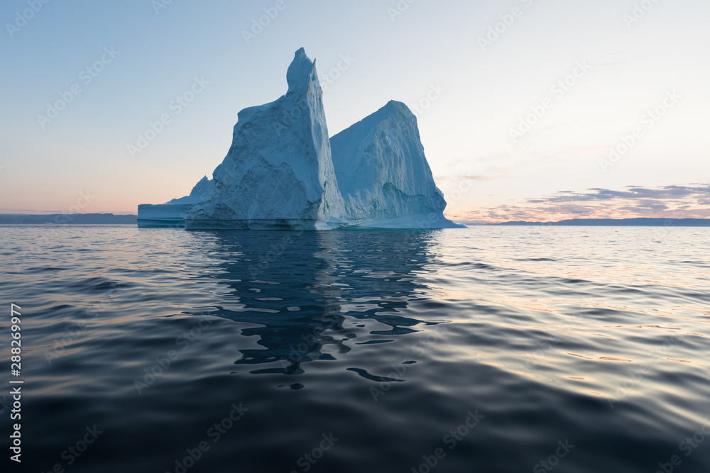 Icebergs in front of the fishing town Ilulissat in Greenland. Nature and landscapes of Greenland. Travel on the vessel among ices. Phenomenon of global warming. Ices of unusual forms and colors. Icebergs in front of the fishing town Ilulissat in Greenland. Nature and landscapes of Greenland. Travel on the vessel among ices. Phenomenon of global warming. Ices of unusual forms and colors.