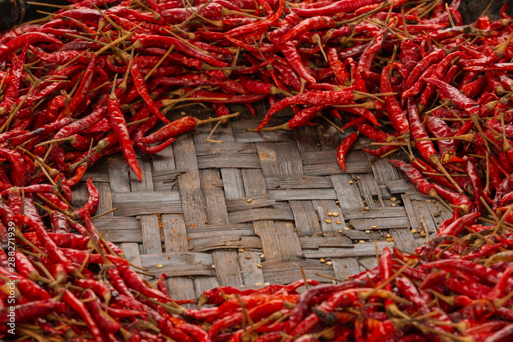 Naklejka premium Red dried chilies placed on the space on the weave.