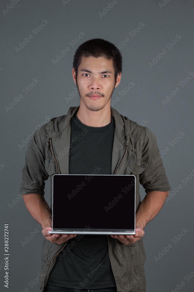 A handsome man with a notebook in his hand and a gray background. A handsome man with a notebook in his hand and a gray background.