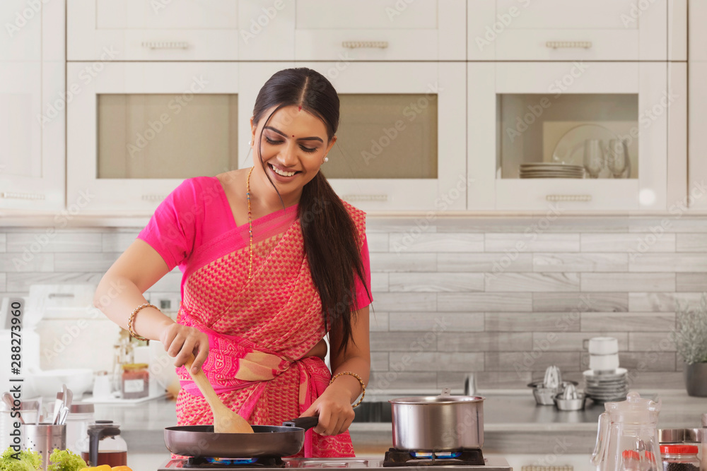 woman in saree cooking in the kitchen woman in saree cooking in the kitchen
