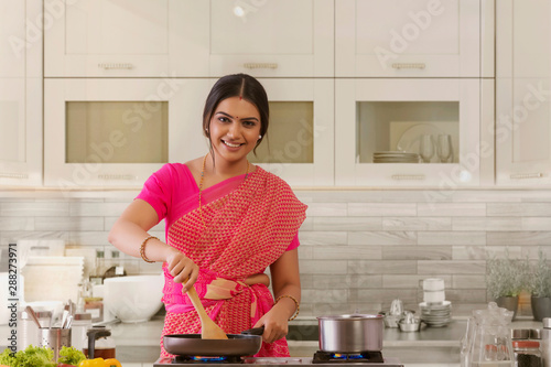 woman in saree cooking in the kitchen	 photo