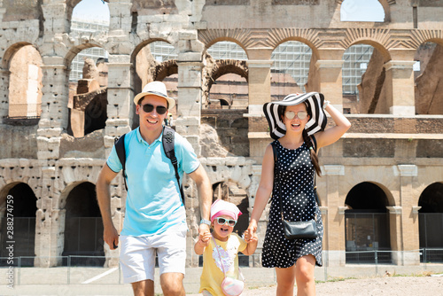 Canvas Print Young Family Running In Front Of Colosseum