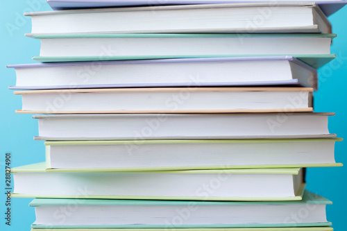 Stack of colorful books on blue background . Education background. Back to school.