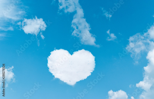 Heart shaped clouds on blue sky background.