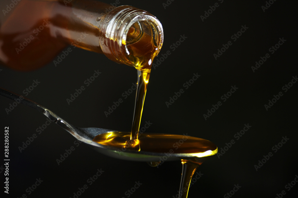 Oil pouring to the spoon from the bottle Oil pouring to the spoon from the bottle