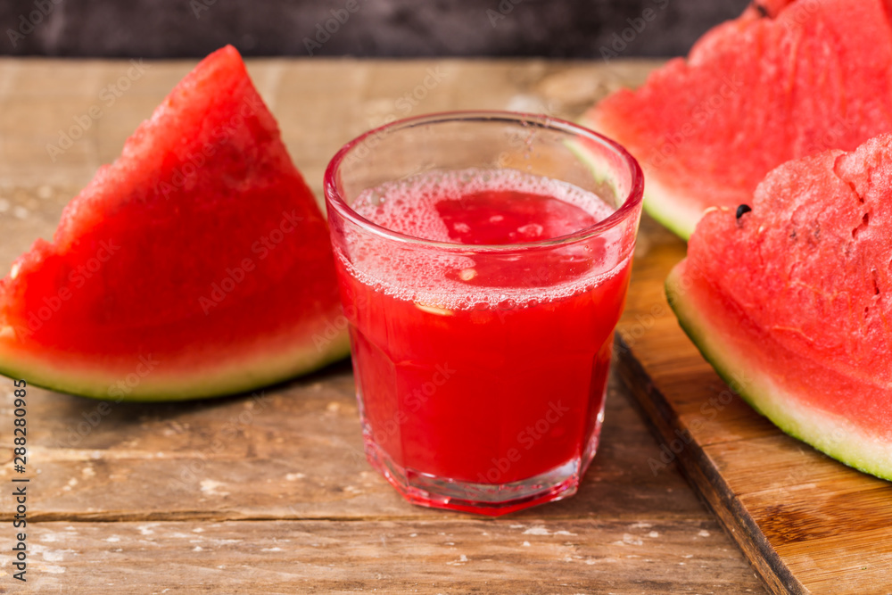 Watermelon juice with slice of watermelon on wooden table Watermelon juice with slice of watermelon on wooden table