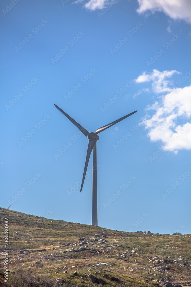View of a wind turbine on top of mountains View of a wind turbine on top of mountains