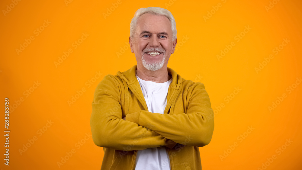 Self-confident senior man with folded arms smiling into camera healthy pensioner Self-confident senior man with folded arms smiling into camera healthy pensioner