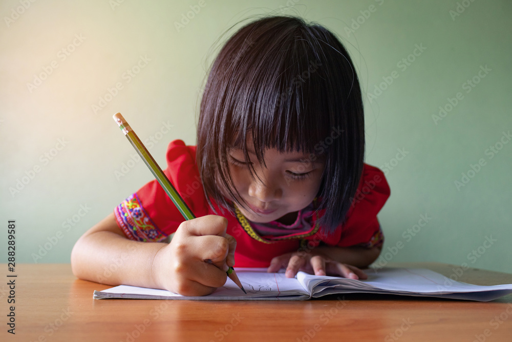 Cute little girl doing homework, reading a book, coloring pages, writing and painting. Children paint. Kids draw. Preschooler with books at home. Cute little girl doing homework, reading a book, coloring pages, writing and painting. Children paint. Kids draw. Preschooler with books at home.