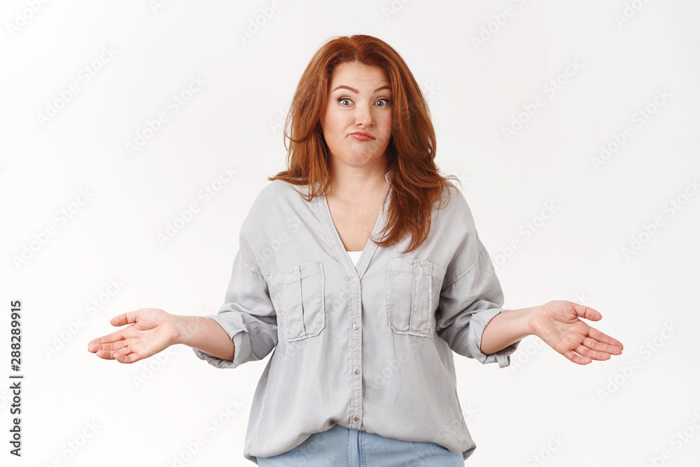 Confused redhead middle-aged shrugging woman spread hands sideways smirking wondered raise eyebrows puzzled have no idea unaware how situation happened standing clueless white background Confused redhead middle-aged shrugging woman spread hands sideways smirking wondered raise eyebrows puzzled have no idea unaware how situation happened standing clueless white background