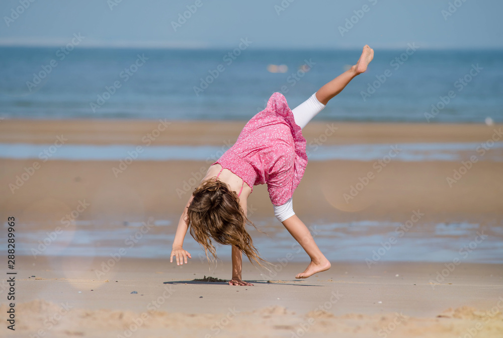 pretty young girl doing antics on the beach Stock Photo | Adobe Stock
