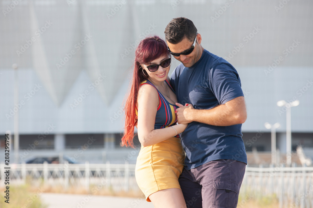 Couple dancing at sunset salsa brazilian zouk. Lovers, dance partners spinning, latin festival dance concept.