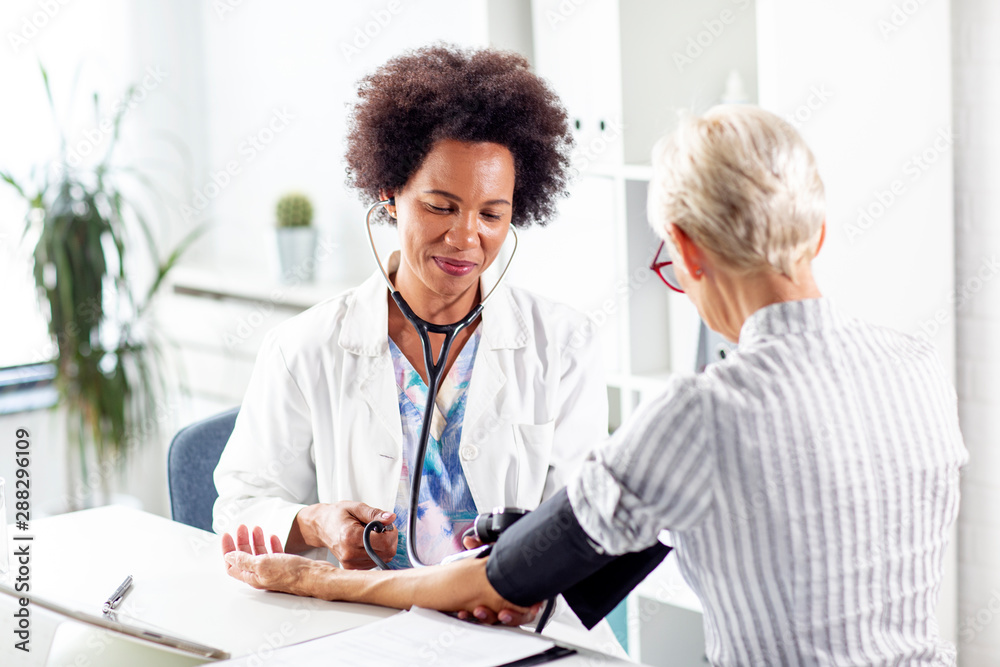 Doctor measure blood pressure mature woman at ambulance Doctor measure blood pressure mature woman at ambulance