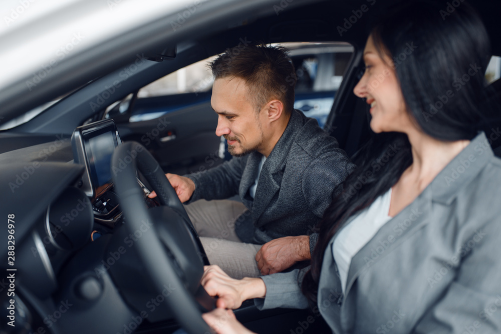 Couple buying new car, woman behind the wheel