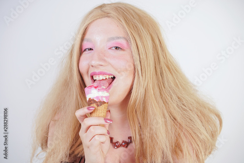 Girl eating ice cream and looking cute on white studio background. happy excited expression portrait of Multicultural Asian young woman model.