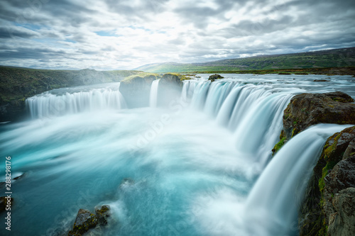 Godafoss waterfall, Iceland. Picturesque long exposure Icelandic landscape of famous landmark in Iceland - waterfall Godafoss. Popular tourist landmark, travel destination in Iceland.