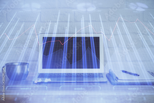 Financial graph colorful drawing and table with computer on background. Double exposure. Concept of international markets.