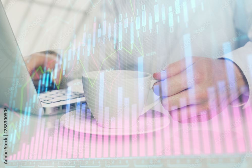 Double exposure of graph with man typing on computer in office on background. Concept of hard work.