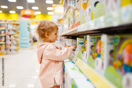 Little girl choosing toys in kids store