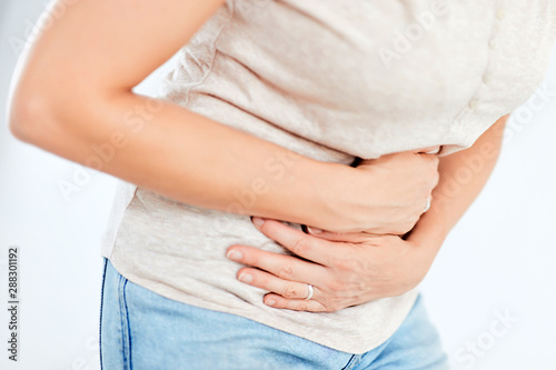 Woman with stomach/ hip issues / problems on the white background. © astrosystem