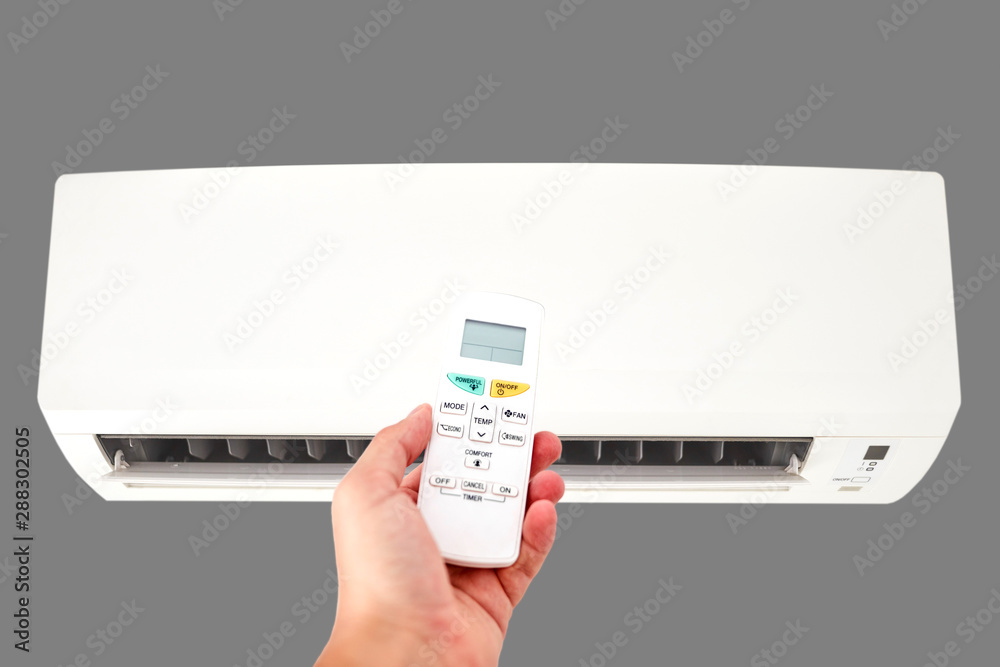 Modern airconditioner unit with a hand holding a remote. Modern airconditioner unit with a hand holding a remote.