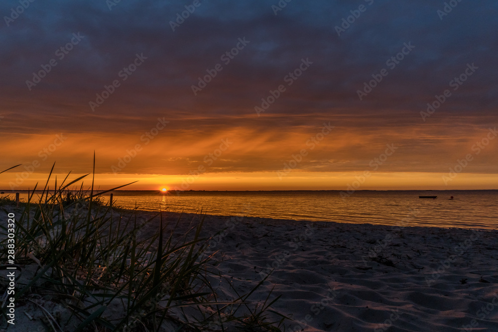 Fototapeta premium Beautiful sunset at the beach with colorful clouds in the sky