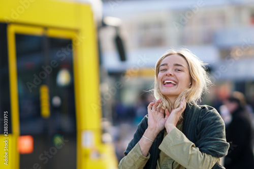 Photography Happy woman in the city with yellow Berlin tramway in the background