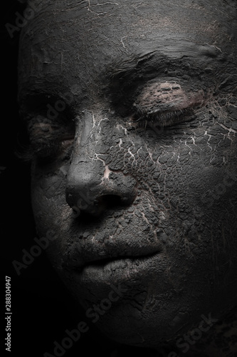 female face with black clay mask