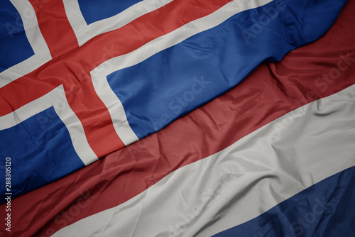 waving colorful flag of netherlands and national flag of iceland.