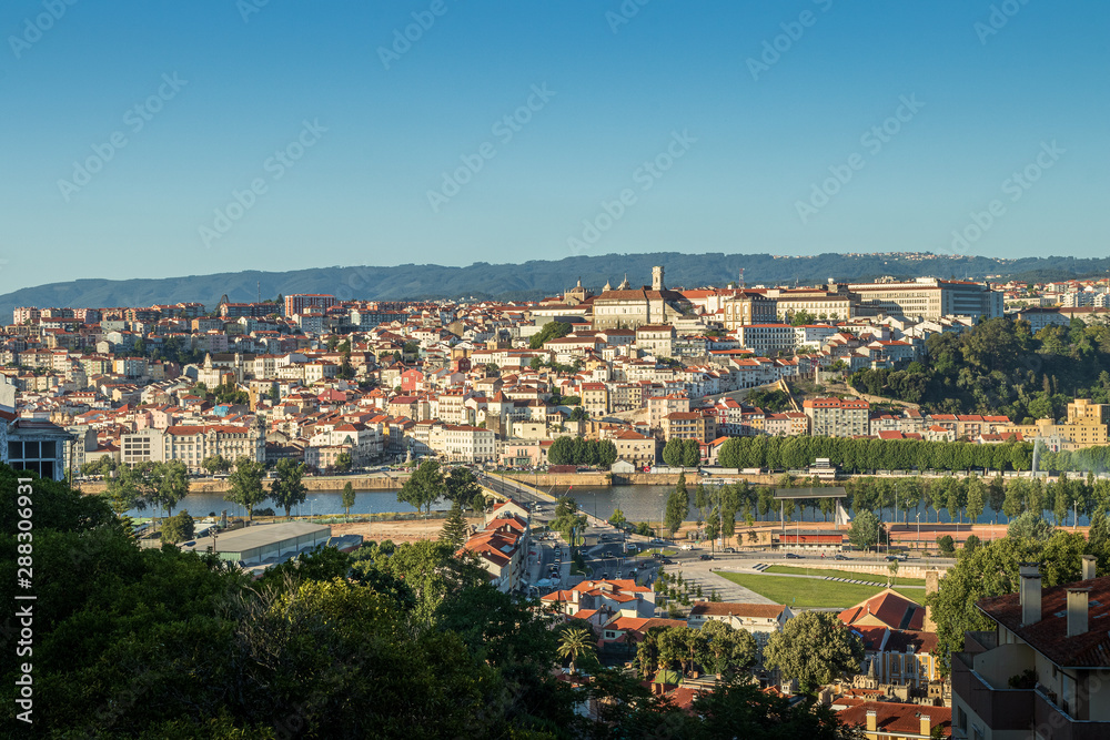 Cityscape of Coimbra in Portugal, from downtown Santa Clara with the Mondego river to the high of Coimbra with the University. At the end of a summer day.