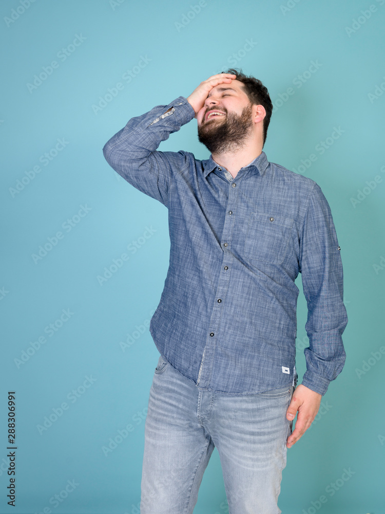 cool and young man with black hair and black beard posing in front of blue background doing different body exprssions with copy space and is happy cool and young man with black hair and black beard posing in front of blue background doing different body exprssions with copy space and is happy