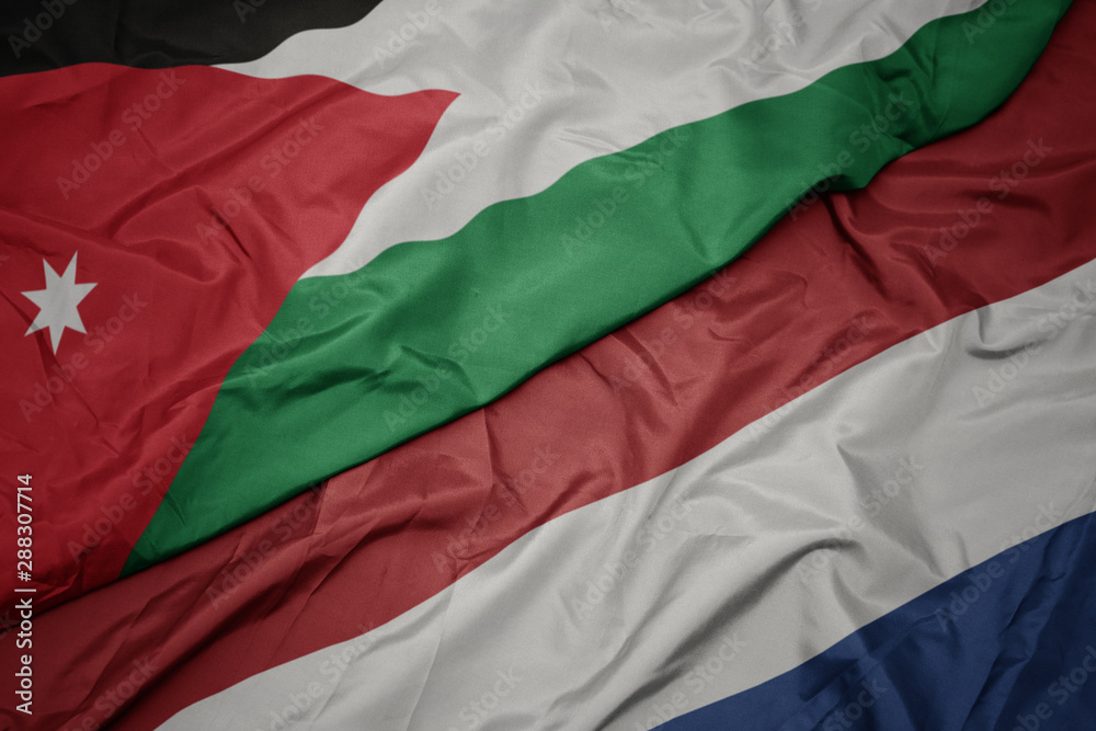 waving colorful flag of netherlands and national flag of jordan.