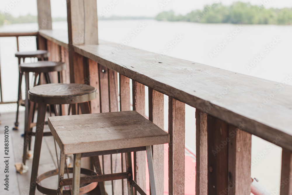 Selective focus of Wooden chair by the cafe terrace on natural blurred background Selective focus of Wooden chair by the cafe terrace on natural blurred background