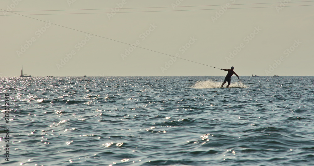 outdoor activities at sea riding on a Board holding a rope. Wakeboarding on the sea