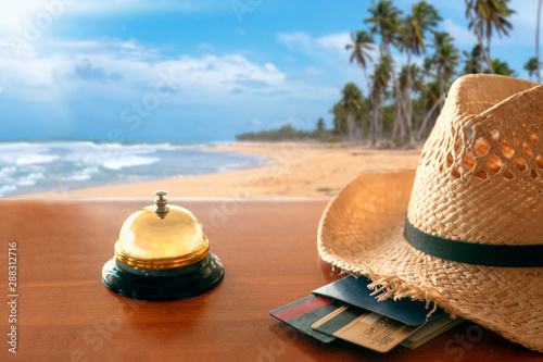 Fototapeta Naklejka Na Ścianę i Meble -  Hotel lobby against the backdrop of a tropical beach. Chekin. Straw hat, passport, bank cards.