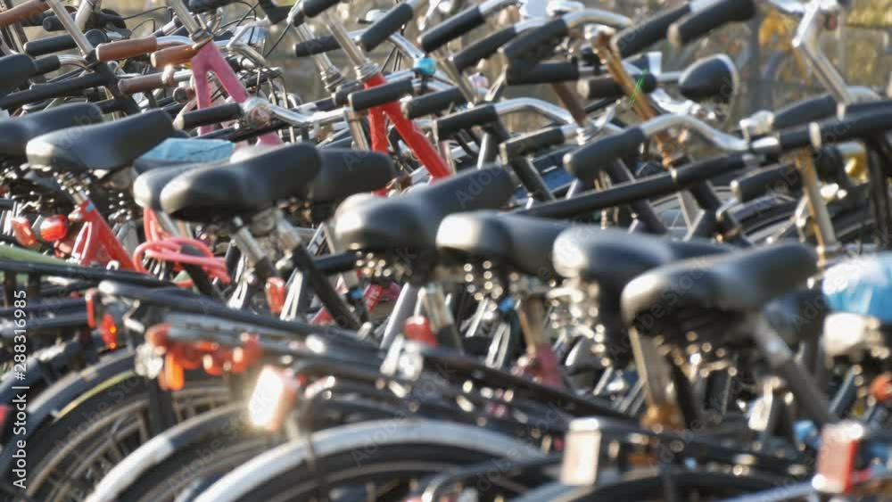 Amsterdam, Netherlands - April 21, 2019: Parking for bicycles. Many different bicycles parked on the street in special parking lots. The problem of bicycle overload in the country Amsterdam, Netherlands - April 21, 2019: Parking for bicycles. Many different bicycles parked on the street in special parking lots. The problem of bicycle overload in the country