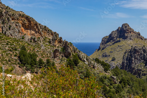 Scenic view at landscape of Serra de Tramuntana on island Mallorca, Spain on a sunny day with rocks in front and mediterranean sea in background