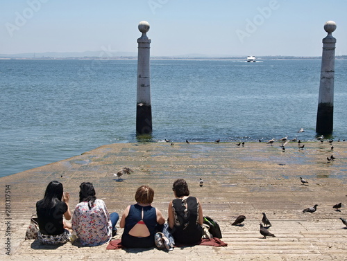 Young people are looking to the Tejo river in Lisbon - Portugal 