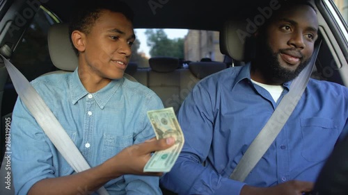 Son asking pocket money from dissatisfied father sitting in car, generation gap photo