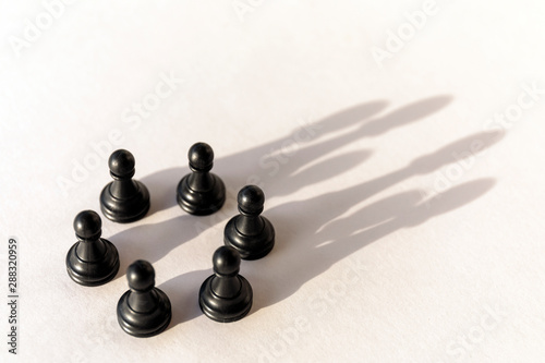 Plastic chess pawn circle with shadow shaped as crown on white background. Teamwork  group agreement and success concept